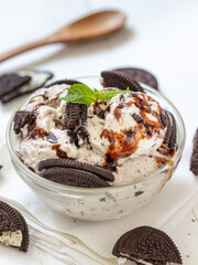 Chocolate cookie and ice cream in a glass bowl with mint leaf on white wooden background, summer sweet and dessert