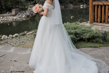 Obraz na płótnie Canvas bride in a wedding dress and with a bouquet