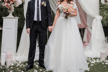 groom with bride near the arch of the wedding