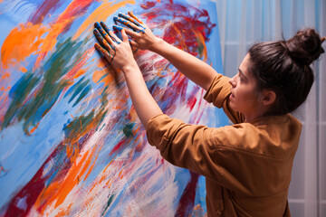 Creative artist painting with fingers on canvas in art studio. Modern artwork paint on canvas,...