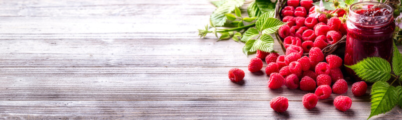 Jar of raspberry jam and fresh berries.