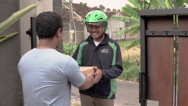 Delivery man delivering package to a man at home - online shopping service concept