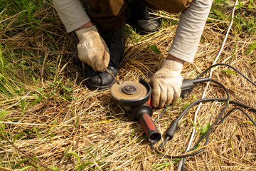 Worker sharpens a screwdriver with a cutter.
