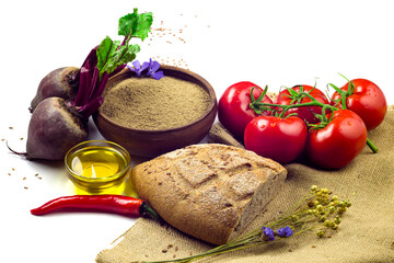 Flax seed in a wooden bowl, flax oil, traditional bread, pepper, tomatoes and beetroots isolated on white background. Traditional, healthy food concept