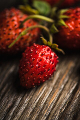 Freshly harvested wild strawberry on the rustic wooden background. Selective focus. Shallow depth of field. 