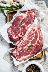 Fresh pork steak. Marble meat on parchment paper. Gray background. Top view