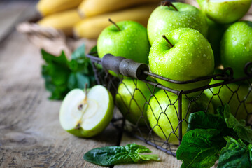 Group of healthy green apples, bananas and mint are ingredients for a smoothie. Detox, diet, healthy, vegetarian food concept.