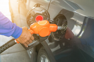 Man handle pumping gasoline fuel nozzle to refuel. facility at petrol station.