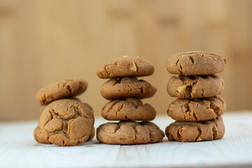 Very tasty peanut butter biscuits on bamboo light brown wooden board, golden baked healthy