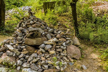 Pile of stones and pebble stacks beside hiking trail