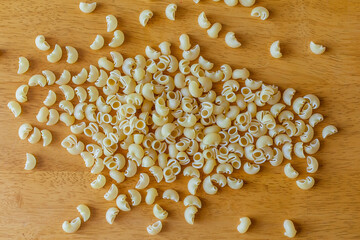 raw macaroni in bowl on wooden background
