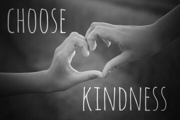 Inspirational quote - Choose kindness. With hands making love sign on black and white background....