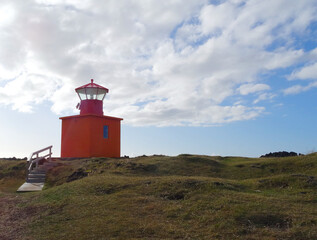 Fototapeta na wymiar Landscape in Iceland. Lighthouse Skalasnagi on Snaefellsnes peninsula in Iceland. Orange lighthouse.