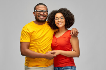 Naklejka premium relationships, vision and people concept - happy smiling african american couple hugging over grey background