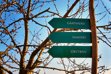 Signs with the text nursery, beekeeping and fruit growing in German as a guide.