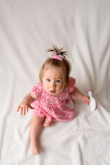 Little girl 6 months old with a comb in hand on a white background.