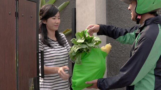 male uber courier driver sending grocery shopping to customer at home