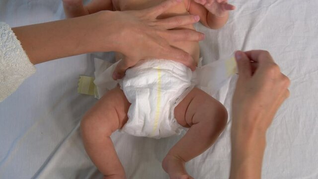 Mother changing diaper on her newborn baby.