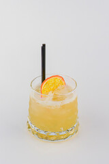 Cold summer alcohol cocktail with ice and orange in a small glass isolated on white background.