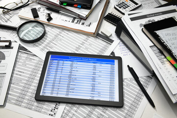 business office desk closeup - tablet computer with tables and graphs on the screen, financial reports, analysis and accounting, set of documents for bookkeeping