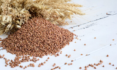 Dietary cereal, Healthy cereal buckwheat for dieting and ears on a light wooden background