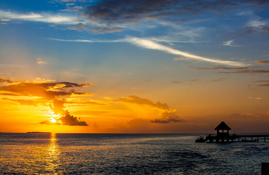 Silhouette of jetty in tropical island in Maldives during sunset time