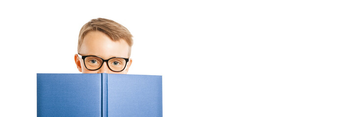 child reads a book against a bright wall