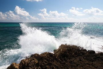 Splash of waves near stone in Caribbean Sea in Mexico summer time