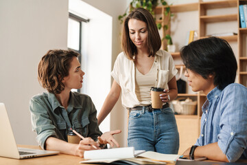 Fototapeta premium Image of colleagues discussing project while working with laptops