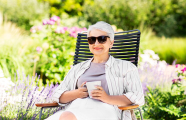 old age, retirement and people concept - close up of happy senior woman drinking coffee or tea at...