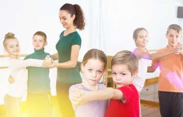 Group of caucasian children dancing tango in dance studio