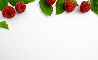 Ripe raspberries isolated on white background close-up. Beautiful red fresh raspberries with leaves along top contour on the table. Top view. Banner for web site. Free space for text