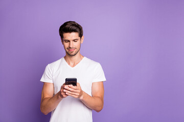 Portrait of his he nice attractive cute focused guy using digital device sending sms free time isolated over bright vivid shine vibrant violet lilac purple color background