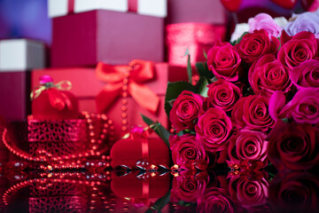 Wedding day concept. Big bouquet of roses and boxes with wedding gifts on glass table.