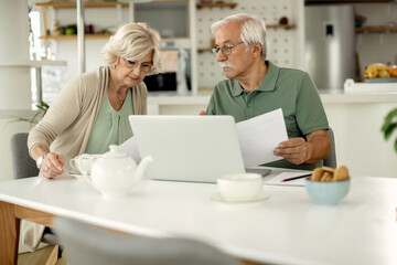 Senior couple going through their financial bills at home.