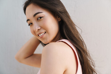 Image of joyful asian beautiful girl smiling at camera