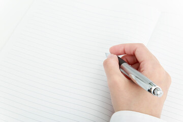 白紙のノートにボールペンで書き込むイメージ