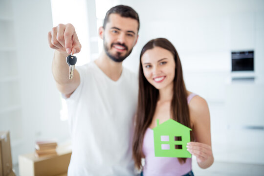 Close-up portrait of his he her she nice attractive cheerful cheery couple embracing holding in hands key house rent insurance trust find investment bank at space flat light white interior