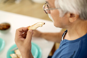 Close-up of mature man having breakfast at home.