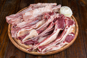 Racks of lamb ready for cooking on dark background