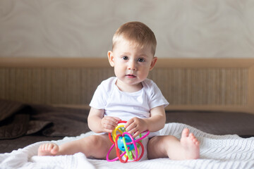 Baby toddler boy, playing in colorful toy in bedroom