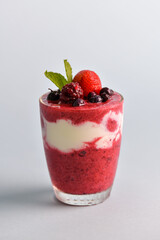 Mixed berry smoothie mixed with yogurt By blending thoroughly in clear glass With berries on top and for those who take care of their shape selective focus at fruits on top