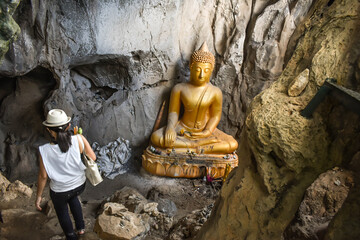 the backside of Asian lady went to the cave for praying Buddha statue in Pha Joh Cave in...