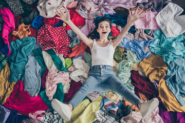 High angle above view photo of crazy funny lady spring cleaning household lying many clothes heap...