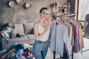 Photo of pretty attacrive nice lady in casual clothes white t-shirt denim skinny jeans standing near wardrobe in living room