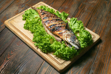 Mackerel grilled on a wooden board with salad