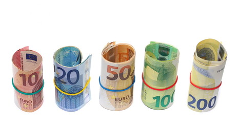 Money rolls, rolled up euro banknotes, bills of various monetary values tied up with rubber band isolated on white background