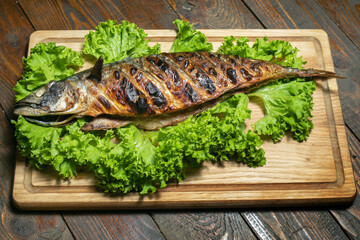 Mackerel grilled on a wooden board with salad