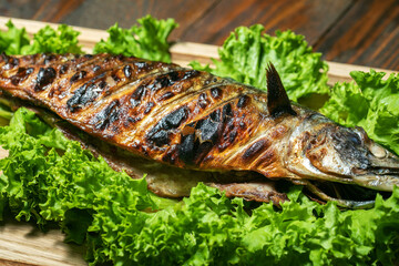 Mackerel grilled on a wooden board with salad