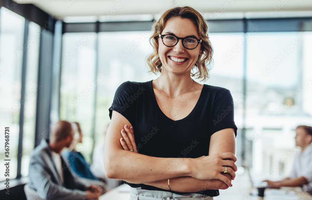 Wall mural Successful businesswoman standing in meeting room